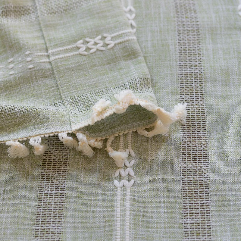 Embroidered striped light green curtains hanging in bedroom window