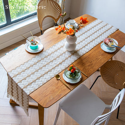 A beige boho crochet table runner on the table