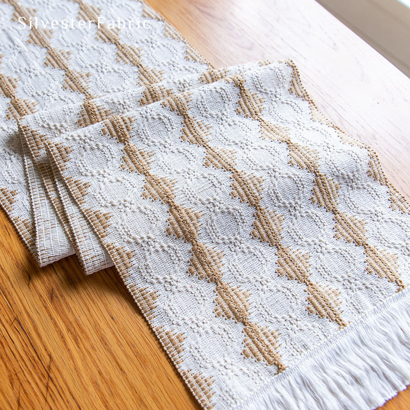 A beige boho crochet table runner on the table