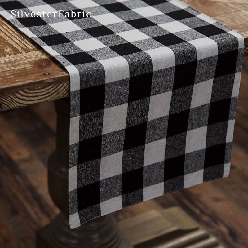 Black and white plaid table runner spread on wooden table