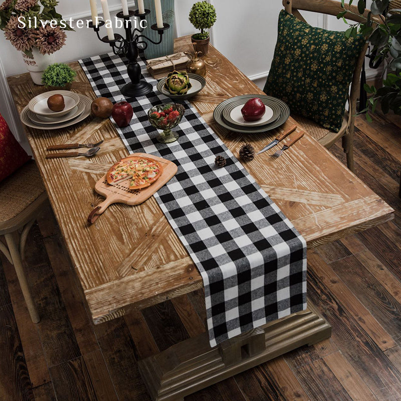 Black and white plaid table runner spread on wooden table