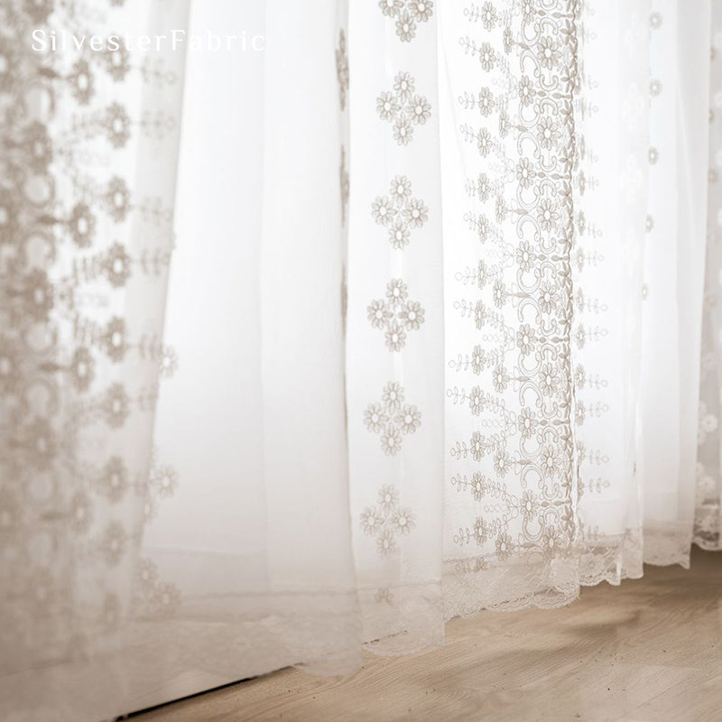 Floral white sheer curtains hanging in bedroom window