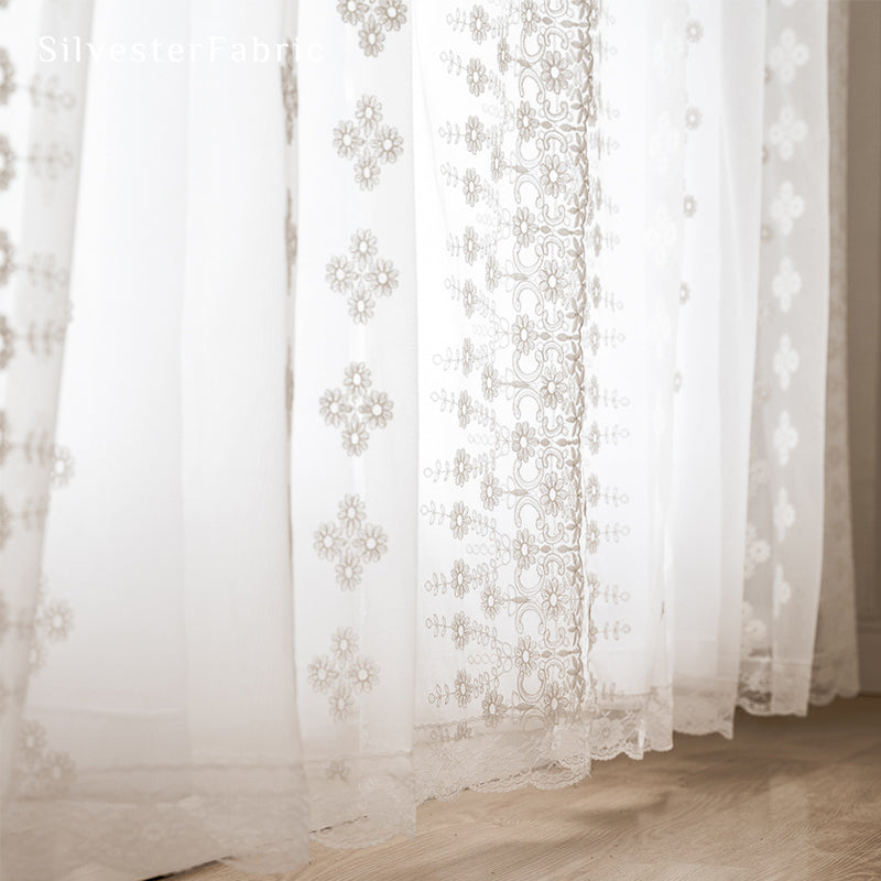 Floral white sheer curtains hanging in bedroom window