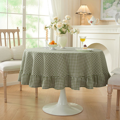 green plaid farmhouse tablecloth draped over round table