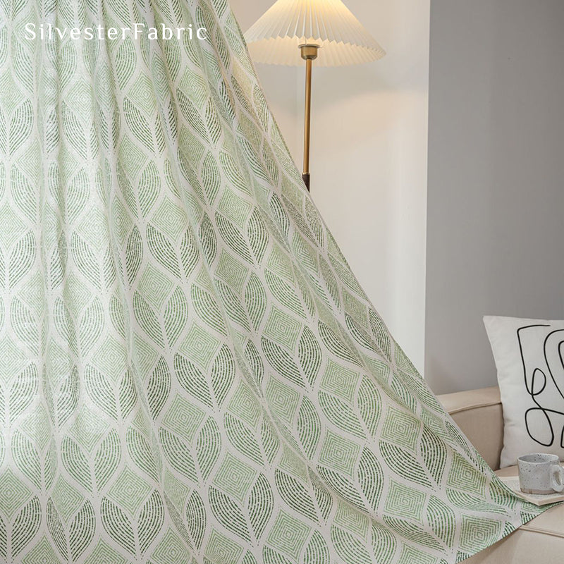 Green sheer curtains hang from the windows and flutter in the wind.