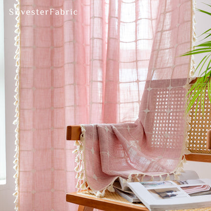 Embroidered plaid light pink curtains hanging in the bedroom window