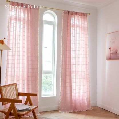 Embroidered plaid light pink curtains hanging in the bedroom window