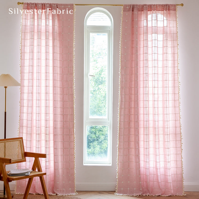 Embroidered plaid light pink curtains hanging in the bedroom window