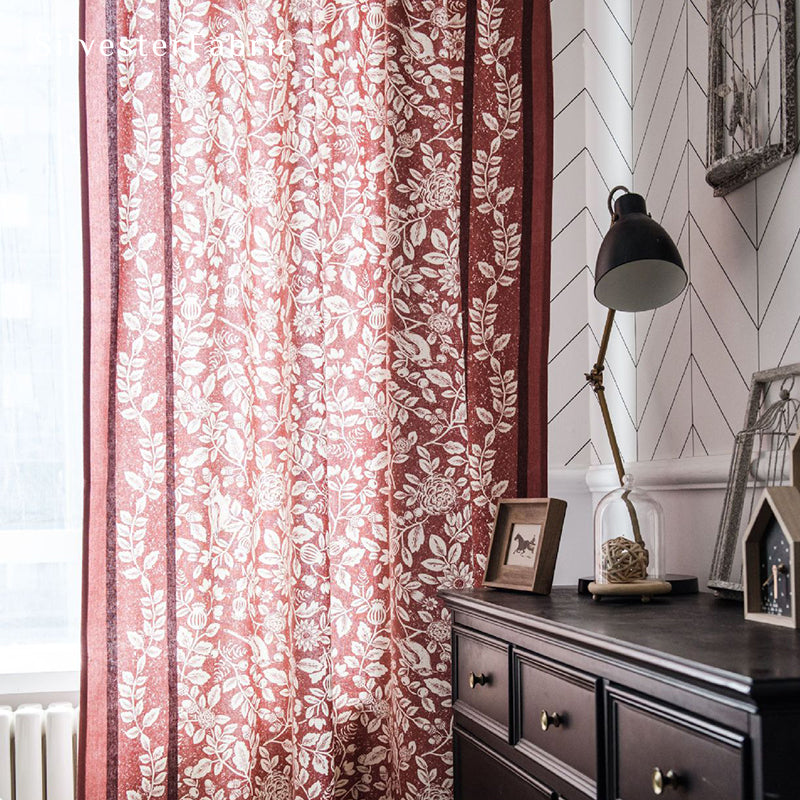 Red linen curtains hang in the windows, and the squirrel and bird motifs on the curtains give the room a particularly festive feel.