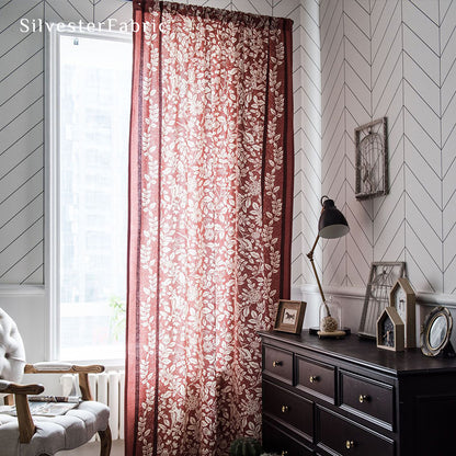 Red linen curtains hang in the windows, and the squirrel and bird motifs on the curtains give the room a particularly festive feel.