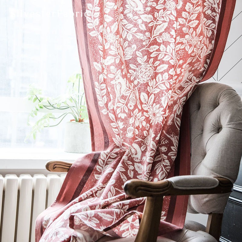 Red linen curtains hang in the windows, and the squirrel and bird motifs on the curtains give the room a particularly festive feel.