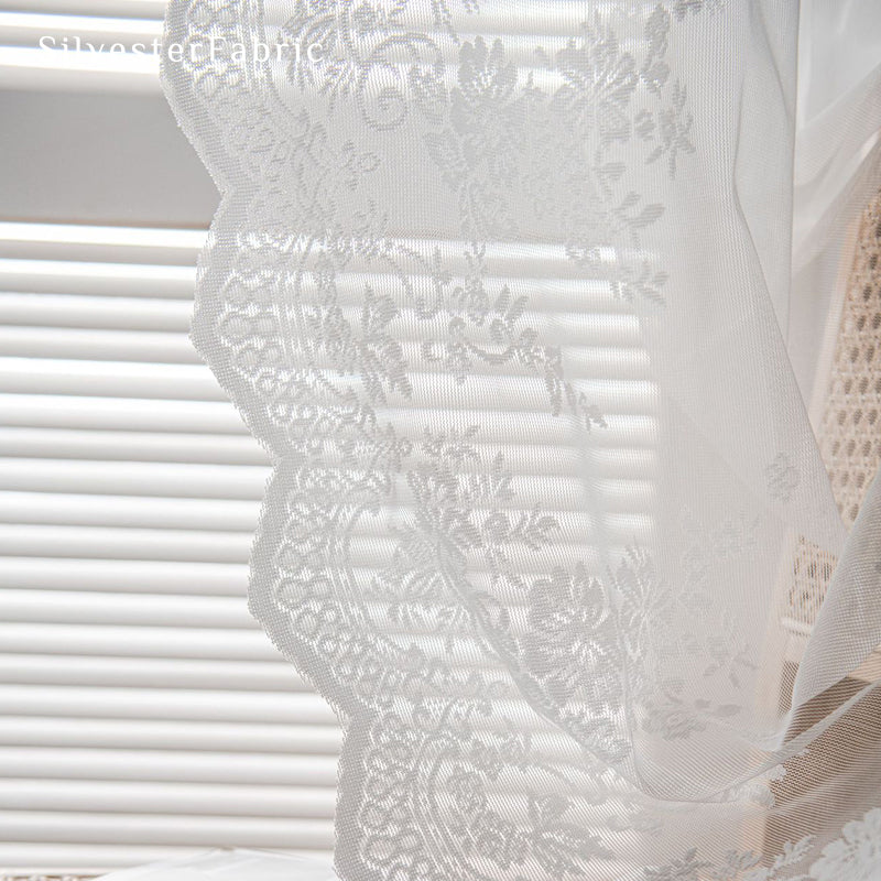 Lace floral white sheer curtains hanging in the window