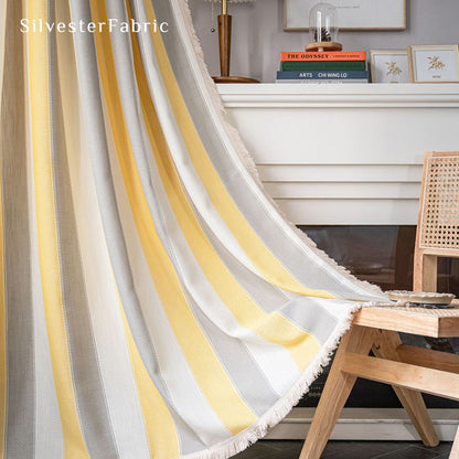 Yellow striped color block curtains hang over the wide bedroom window