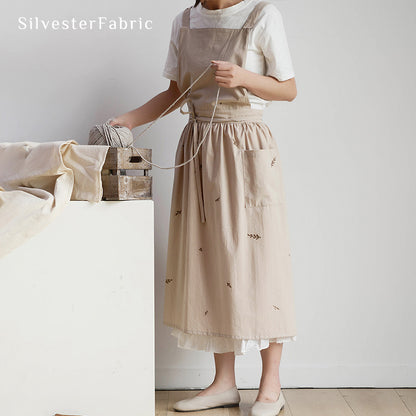 Lady working in a beige embroidered apron