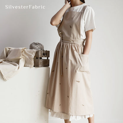 Lady working in a beige embroidered apron