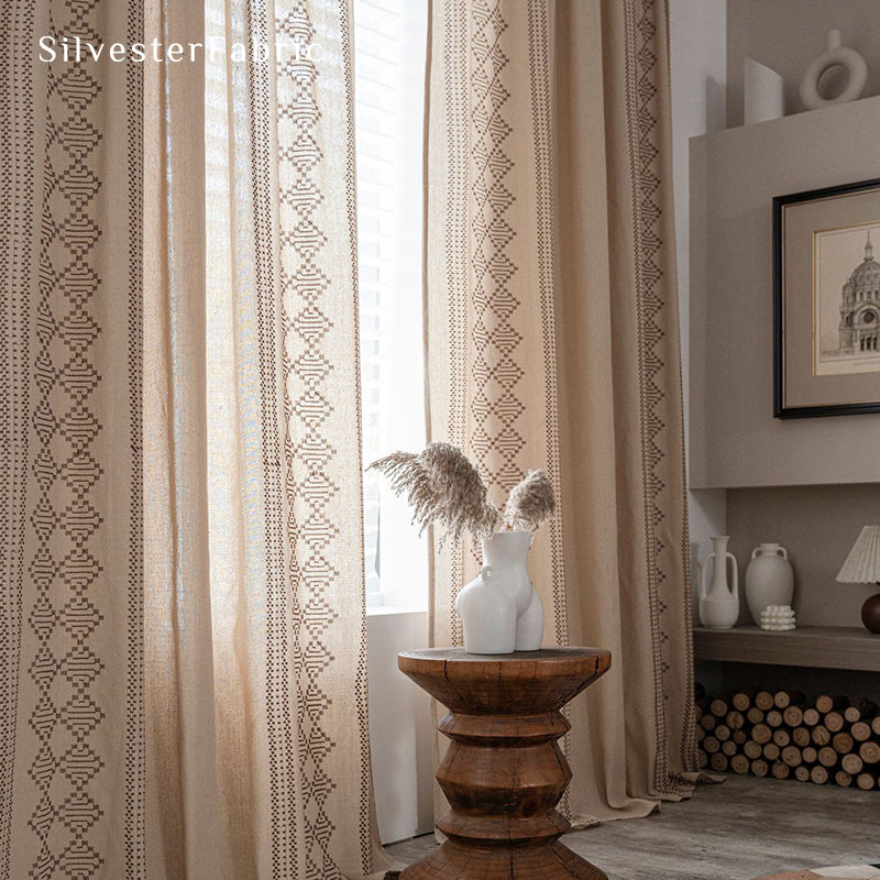 Beige linen curtains with embroidery on both sides hang in the window