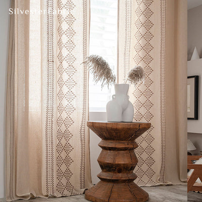 Beige linen curtains with embroidery on both sides hang in the window