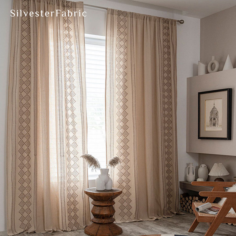 Beige linen curtains with embroidery on both sides hang in the window