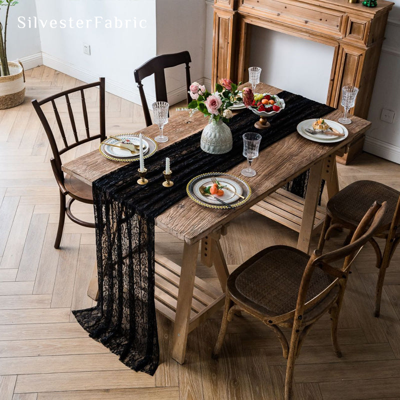 black floral lace table runner laid flat on dining table
