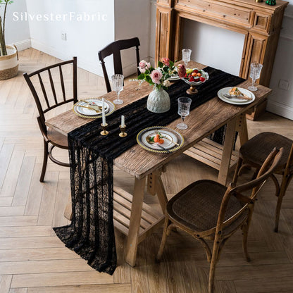 black floral lace table runner laid flat on dining table