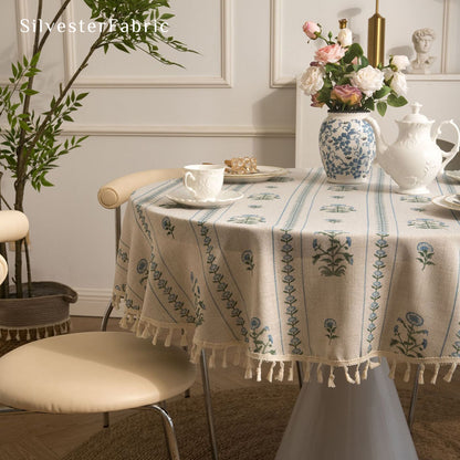 blue floral round farmhouse tablecloth styled with plates and napkins