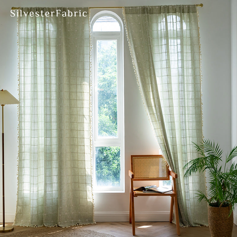 Embroidered plaid light green curtains hanging in the bedroom window