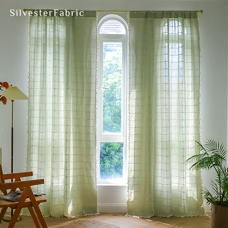 Embroidered plaid light green curtains hanging in the bedroom window