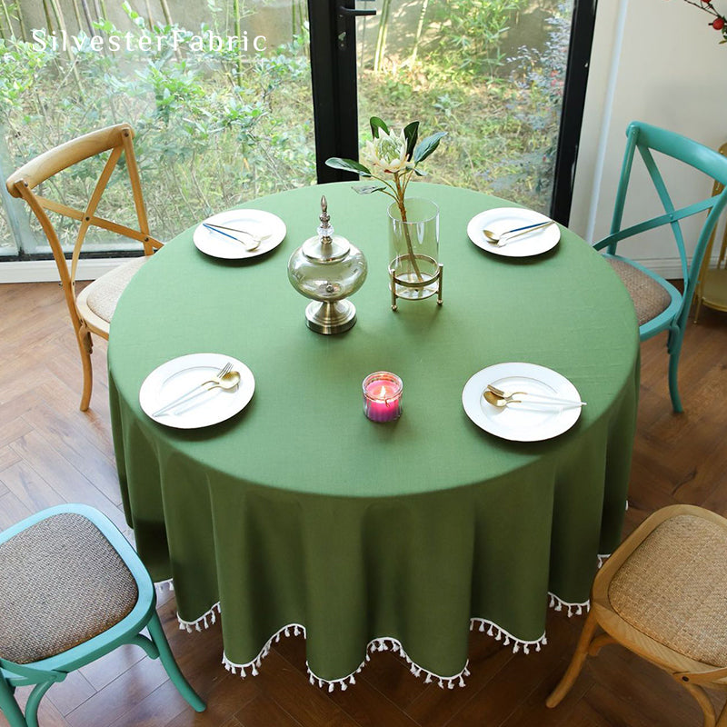 A round green tablecloth covers the round table