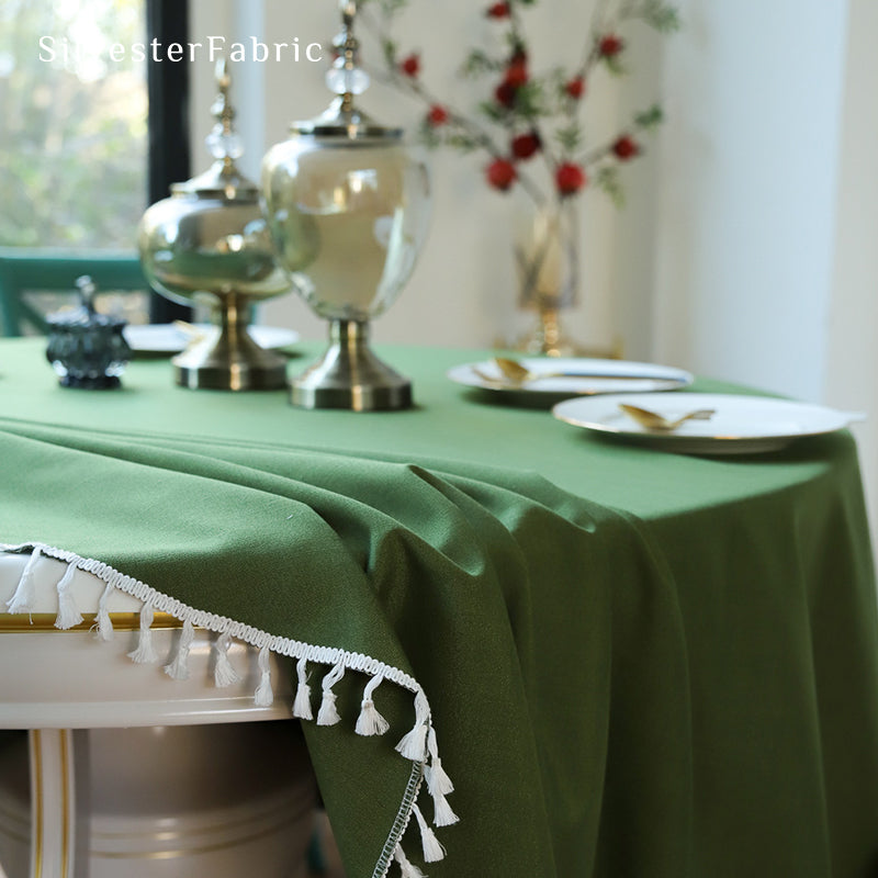 A round green tablecloth covers the round table