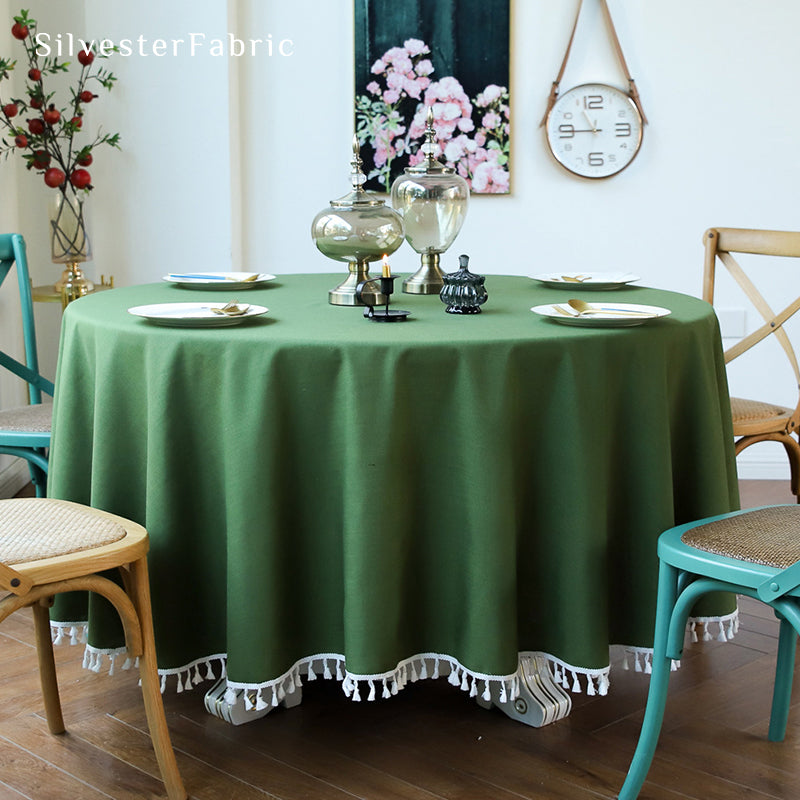 A round green tablecloth covers the round table