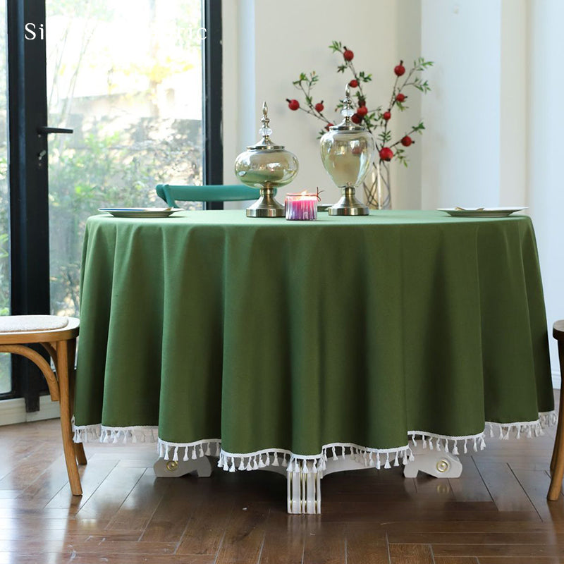 A round green tablecloth covers the round table