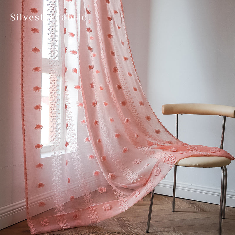 Pink sheer curtains hang on the bedroom window