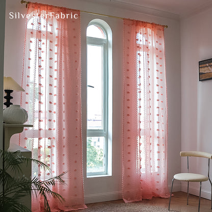 Pink sheer curtains hang on the bedroom window