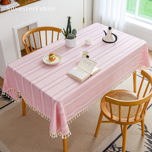 Striped embroidered pink tablecloth covers the table