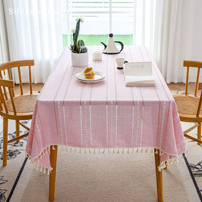 Striped embroidered pink tablecloth covers the table