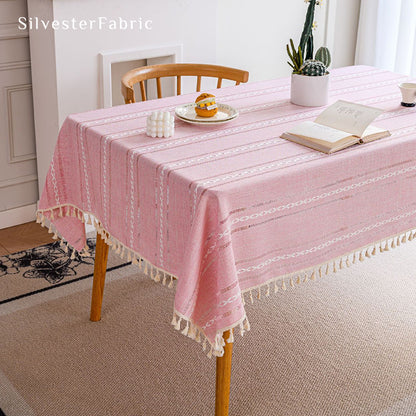 Striped embroidered pink tablecloth covers the table