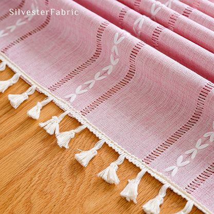 Striped embroidered pink tablecloth covers the table