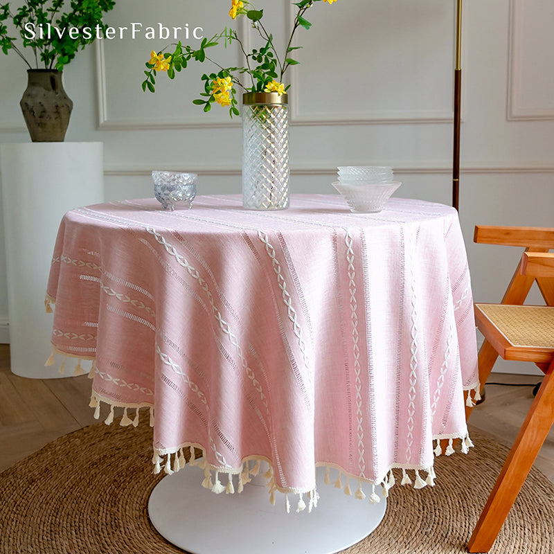 Striped embroidered pink tablecloth covers the table