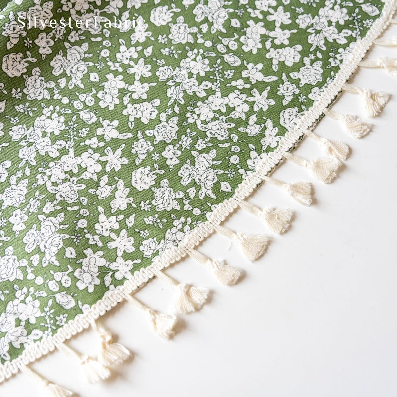 White floral print green tablecloth spread on table