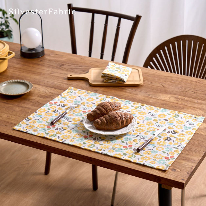 Yellow floral farmhouse placemats on rectangle table with runner