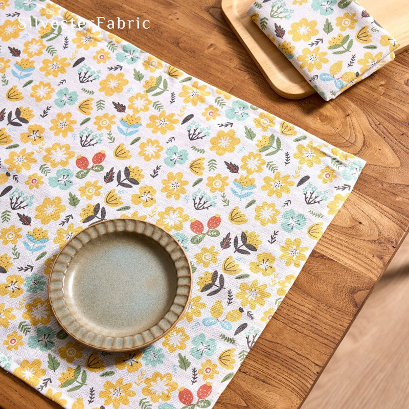 Yellow floral farmhouse placemats laid flat on dining table
