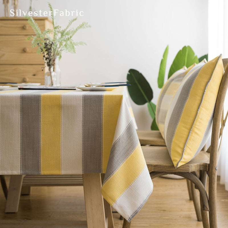 yellow striped farmhouse tablecloth laid flat on dining table